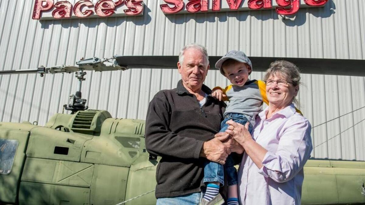 Paul Pace, left, and Roberta Pace, right, hold their grandson Sam Pace in front of their antique business, Pace’s Salvage, on Wednesday, Oct. 5, in Bellingham.
