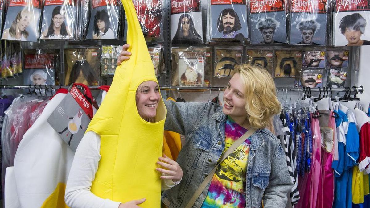 Josie Rapacz, left, tries on a banana costume with the help of her friend Maddy Gehr in the newly expanded costume area in the back of Value Village on Friday, Oct. 21, in Bellingham.