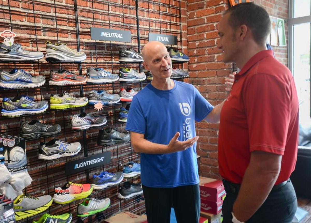 BBay Running owner David Penrose, left, talks with sports chiropractor Eric DeRoche about shoes at the State Street store in Bellingham in 2016.
