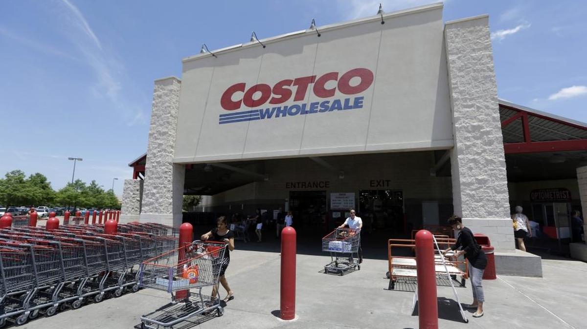 In this June 4, 2014 photo, shoppers push carts out of a Costco in Plano, Texas. Costco has struck a deal for Citi to be the exclusive issuer of its co-branded credit cards, with Visa replacing American Express as the card network.
