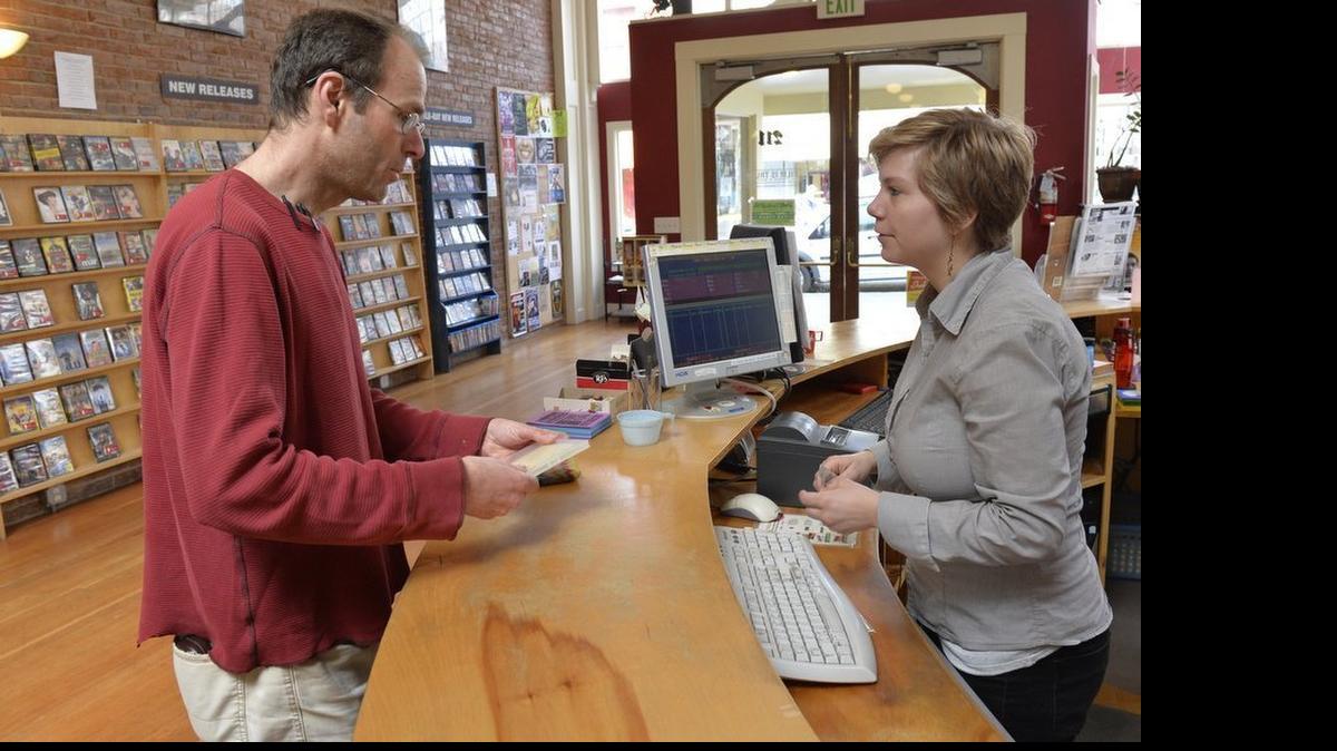Customer Joe Gibson of Ferndale rents a movie from manager Dee Dee Chapman at Film is Truth in downtown Bellingham Friday afternoon, March 27, 2015. The video rental store is transitioning from a company to a non-profit and is preparing to move to the Public Market building.
