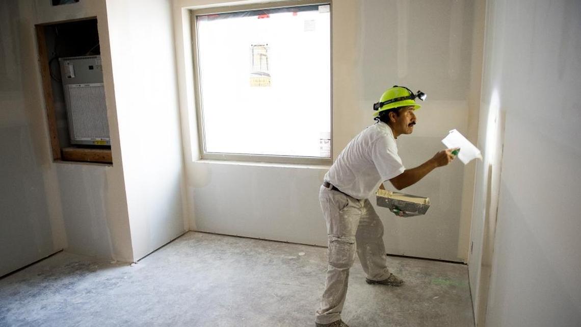 Rigoberto Flores spreads drywall mud on the wall of a room at the Holiday Inn Hotel and Suites near the Bellingham airport on Friday, Aug. 26.