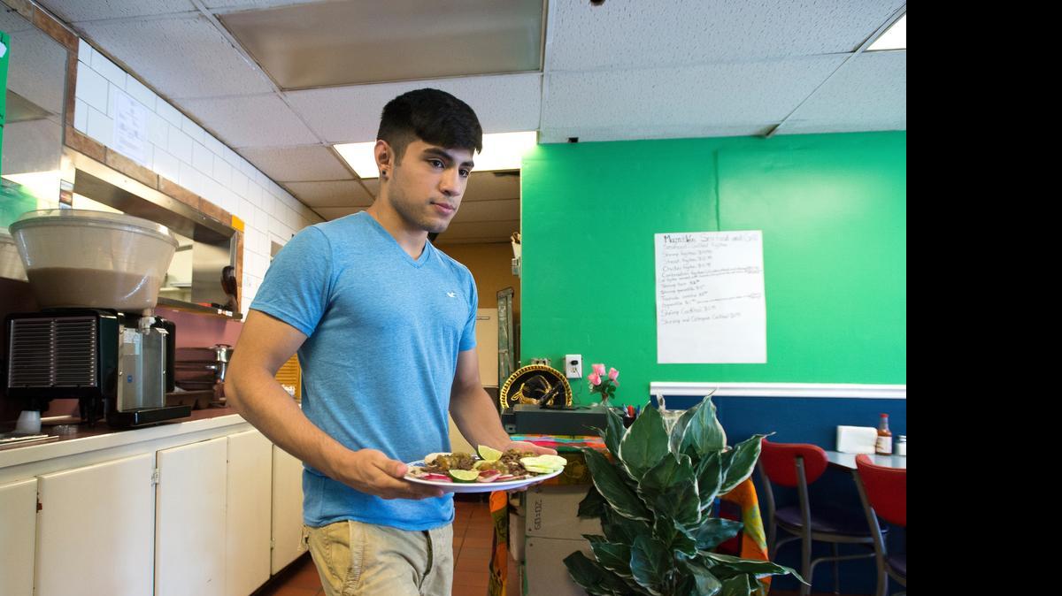 
Mazatlan Seafood and Grill employee Kevin Torres carries four carne asada tacos to a customer on Thursday, June 25, in Ferndale. The restaurant recently opened on Main Street.
