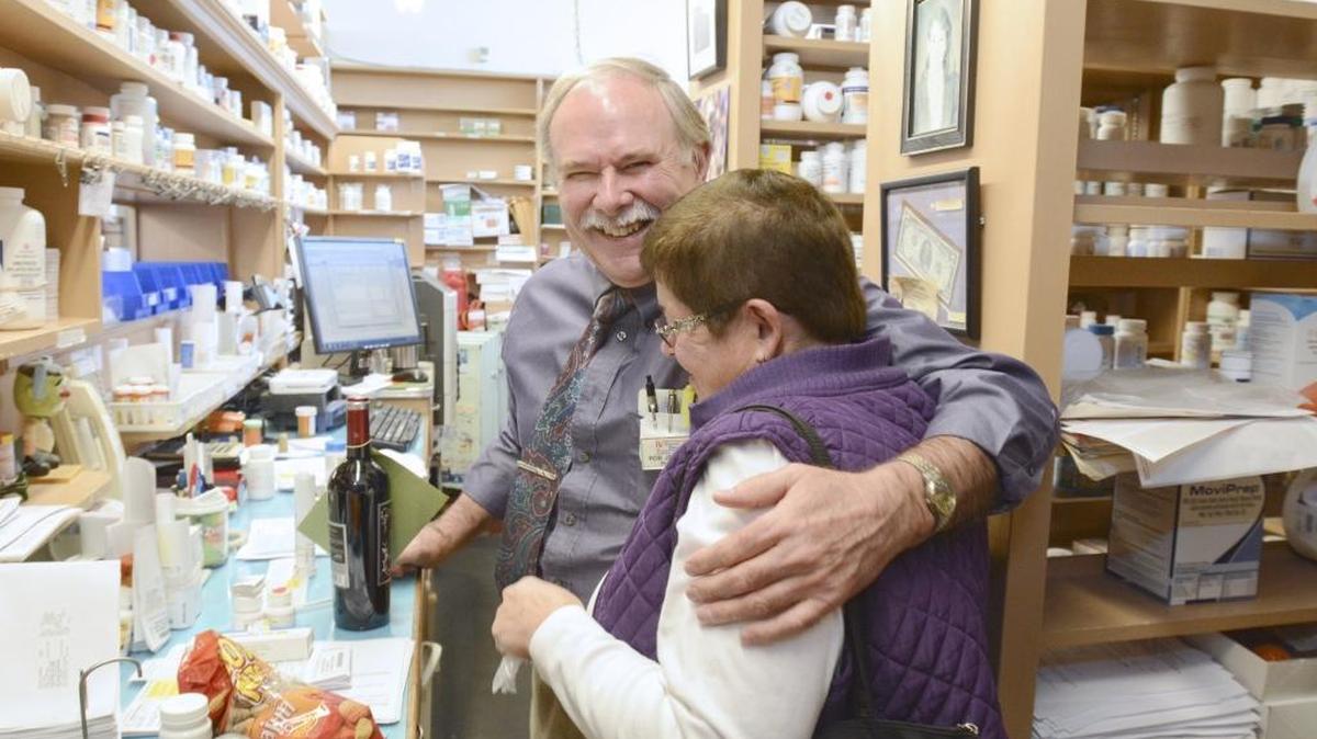 Pharmacist and Fairhaven Pharmacy owner Rob Johansen gets a hug from former employee Claudia Marsh Tuesday, Oct. 20, 2015, after she brought him a bottle of wine on the last day of business at the 126-year-old store. The pharmacy was one of several significant Whatcom County store closures in 2015.