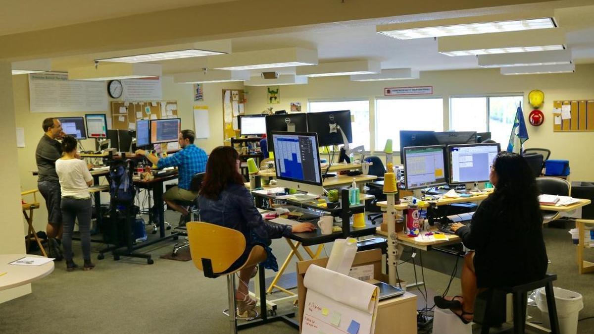 Emergency Reporting employees at work in their former offices on Coho Way in Bellingham. The company recently moved into a larger office space in the Barkley district.