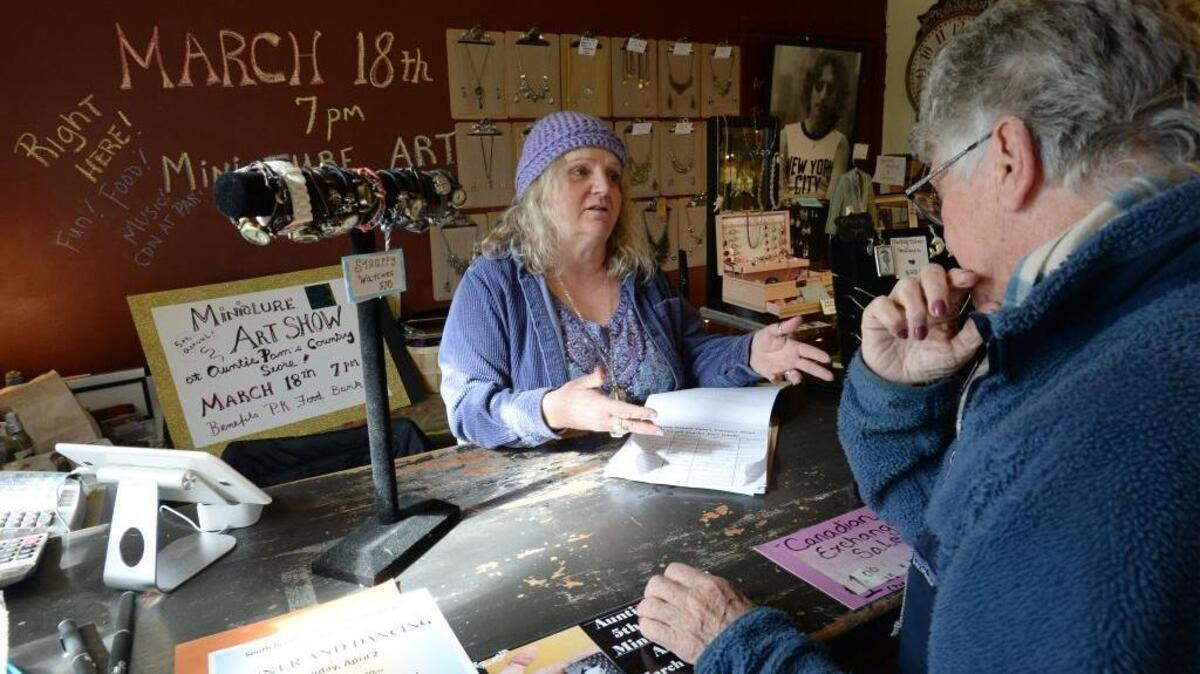 Pamala Sheppard, left, asks customer Eileen Binnie of Tsawwassen, B. C., Wednesday, March 8, 2017, to sign a petition to Trader Joe’s. The petition asks the grocery chain to let Sheppard sell its some of its products in her Auntie Pam’s Country Store in Point Roberts, Wash.