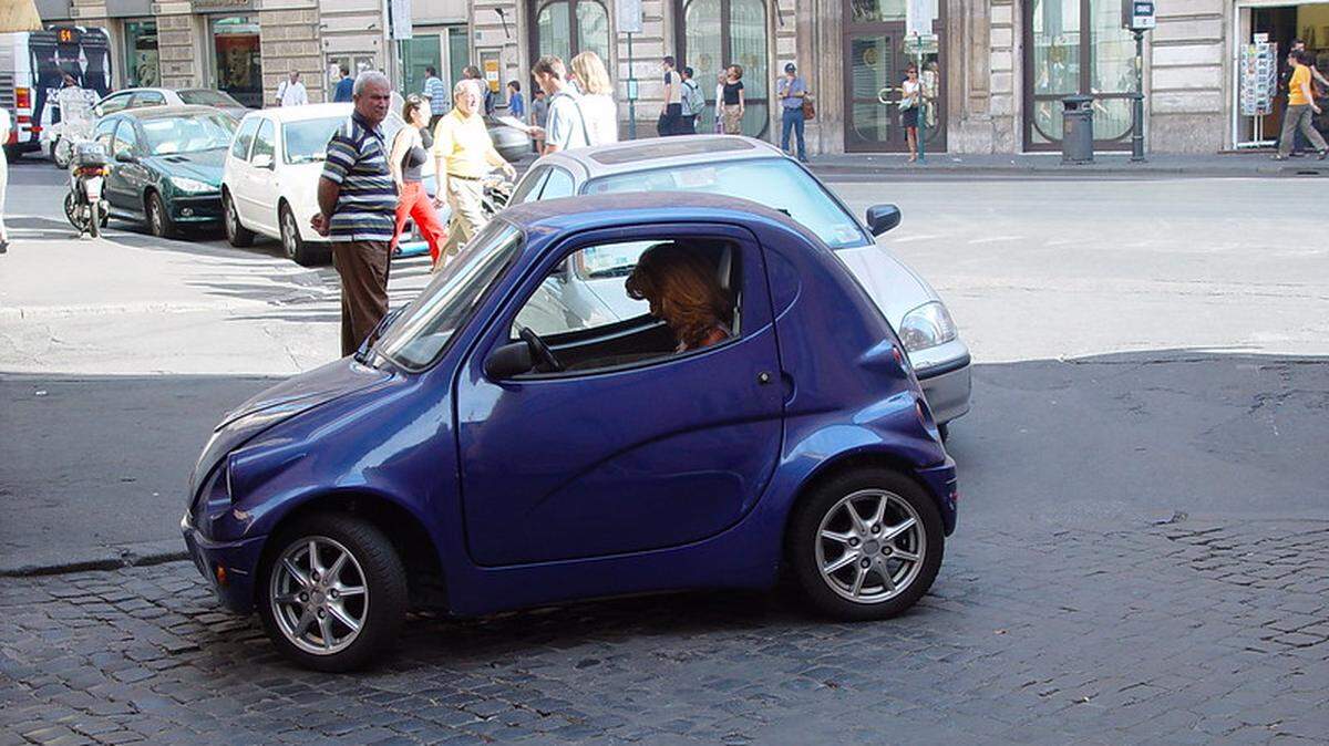 A small car parked streetside in Italy.