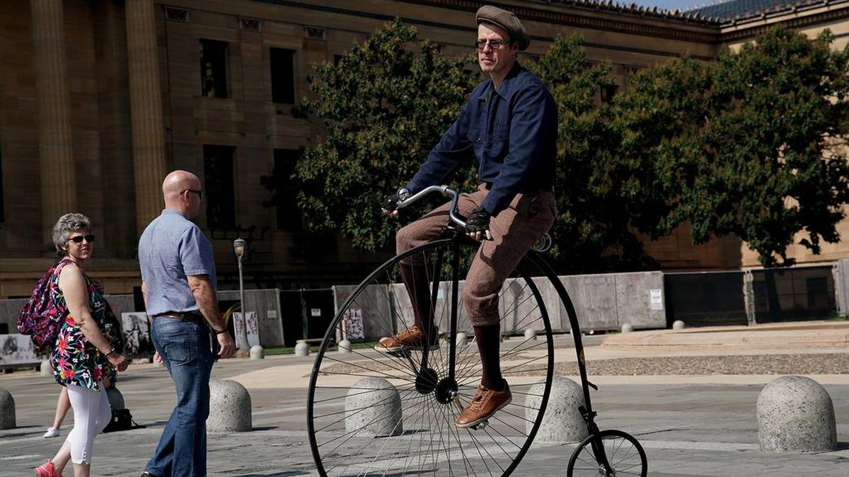 Paul Salter rides with his penny-farthing bicycle outside the Philadelphia Museum of Art.