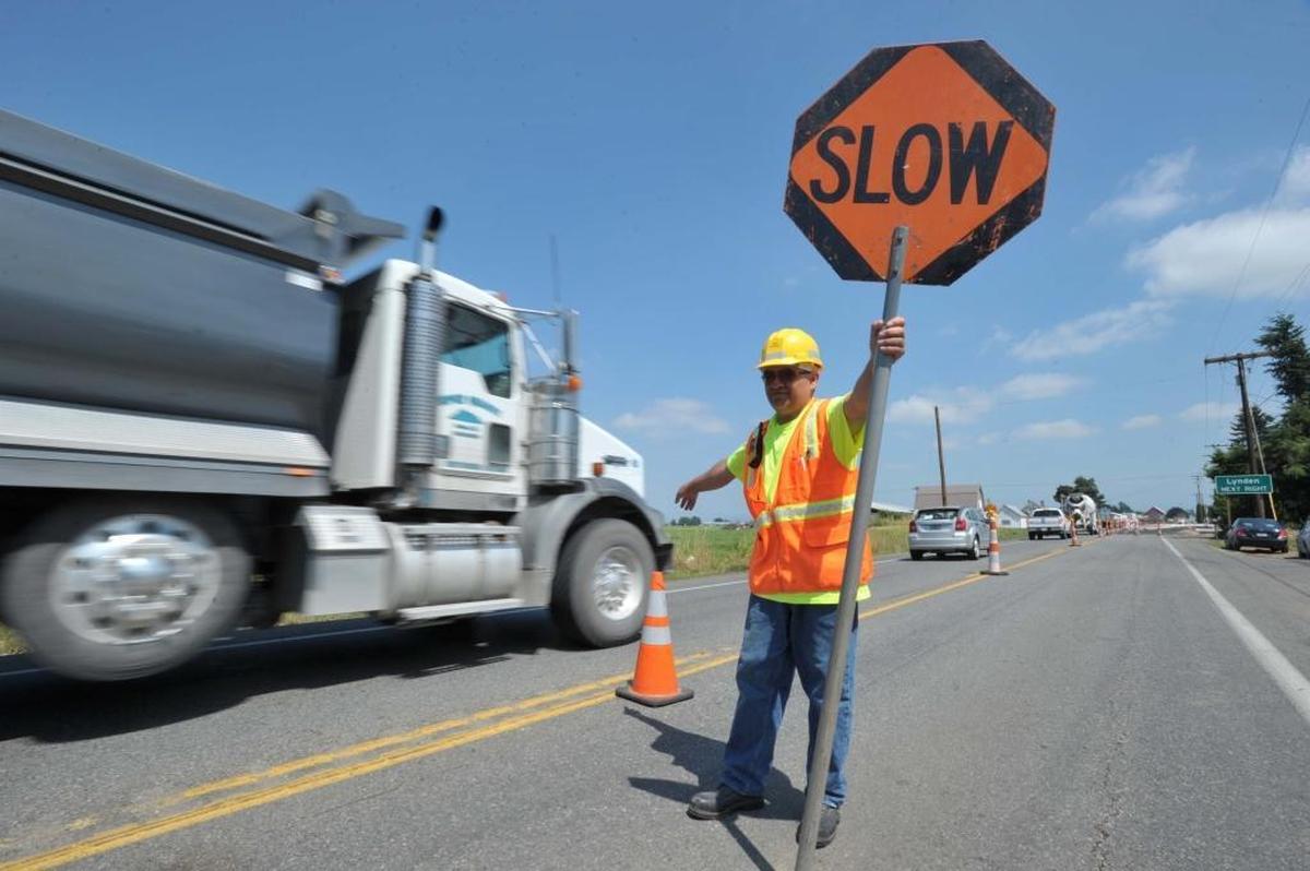 A flagger directs traffic through two roundabouts under construction on Badger Road north of Lynden in 2013.