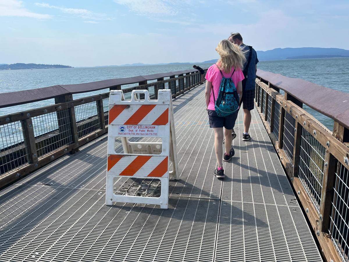Pedestrians walk past a damaged section of Little Squalicum Pier in Bellingham on Aug. 27, 2025. A city official said the pier may be partially or entirely closed during repair work.