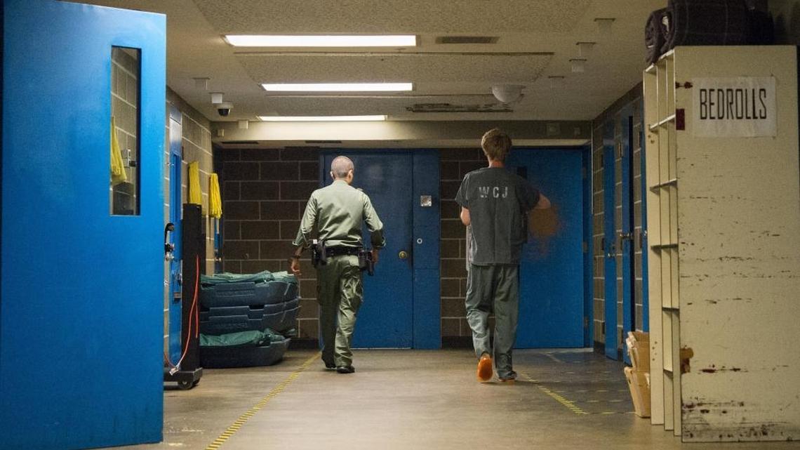 A deputy escorts an inmate to a minimum security housing area July 4, 2015, at Whatcom County Jail in Bellingham, Wash.