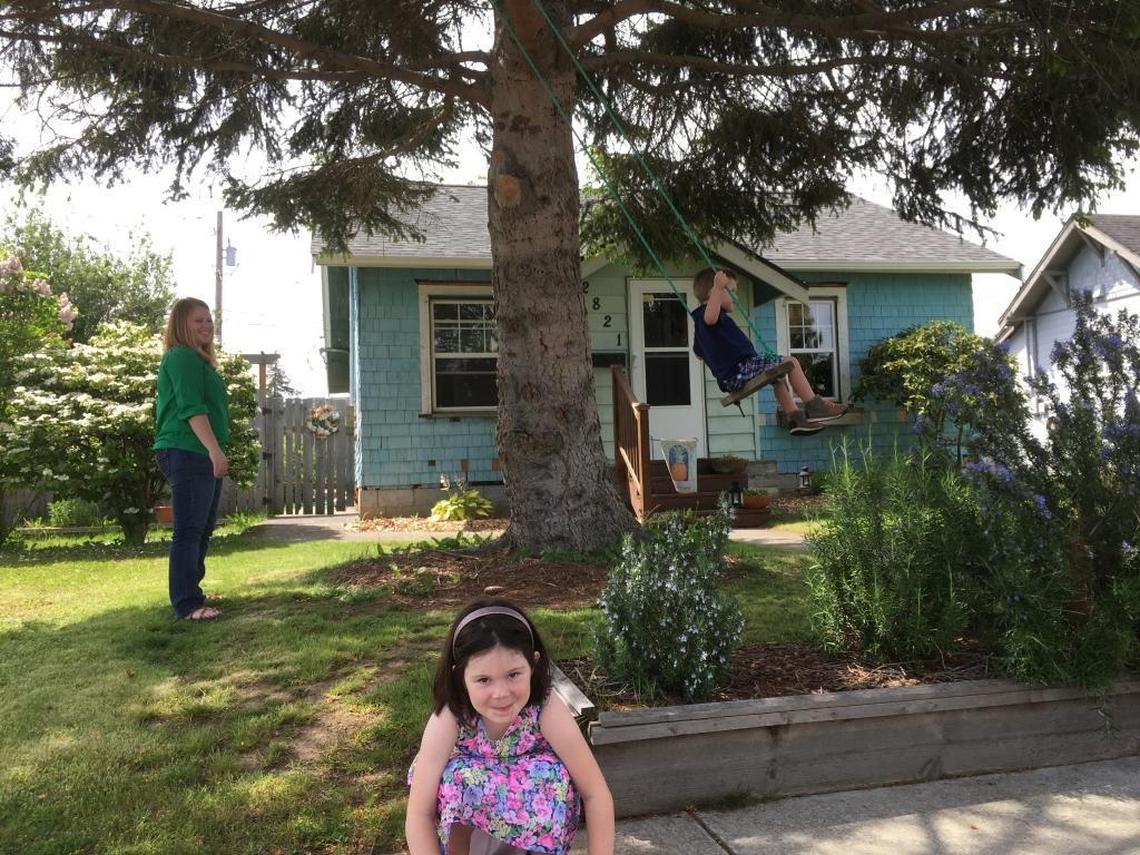 Chelsea Jackson, left, pushes her 3-year-old son Lionel Jackson in a front-yard swing. In the foreground is Regina Jackson, 5.