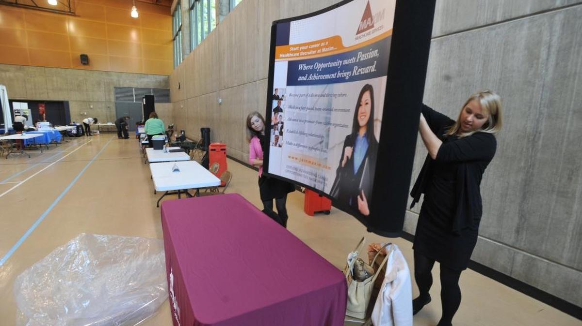 Maxim Healthcare Services recruiters Ali Gibson, left, and Austin Wiesehan set up their display at the 2011 Winter Career Fair at Western Washington University. Both WWU and Bellingham Technical College have job fairs set for spring 2016.