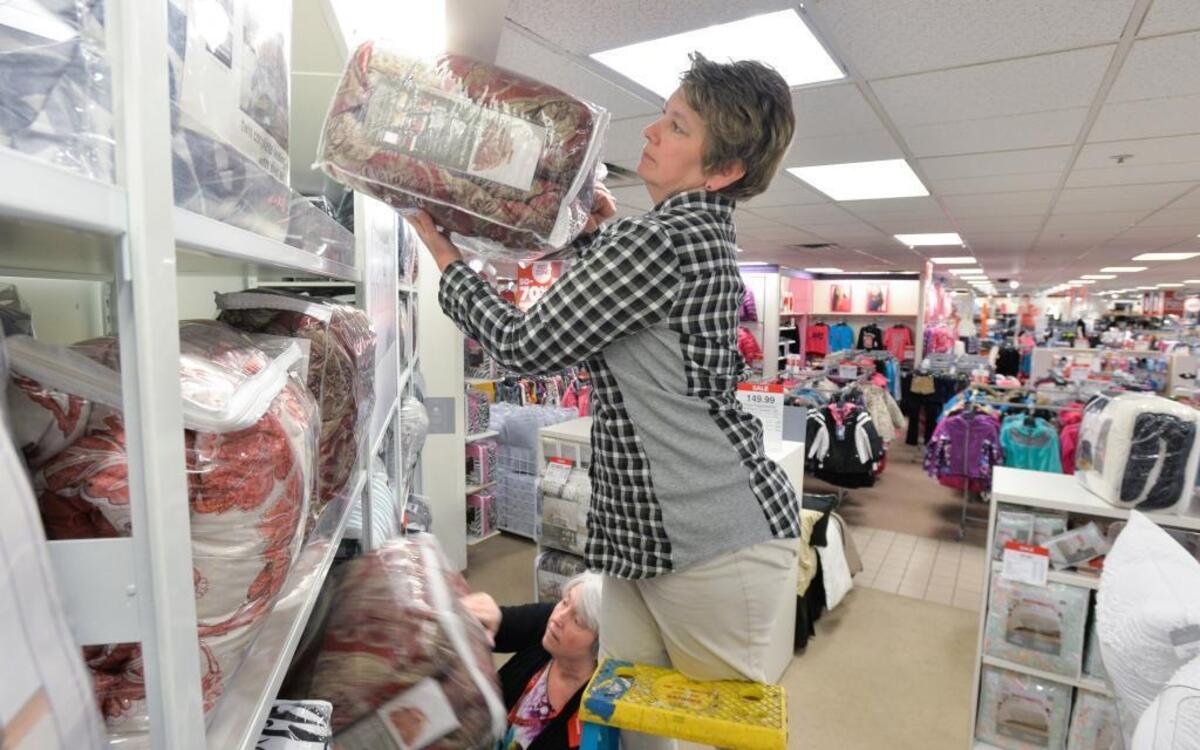 JC Penney store manager Janis Haines, top, and home department supervisor Debbie Brock put up comforters in at the Bellis Fair store in Bellingham, Wednesday morning, Nov. 25, 2015. The store opens at 3 p.m. on Thanksgiving Day.