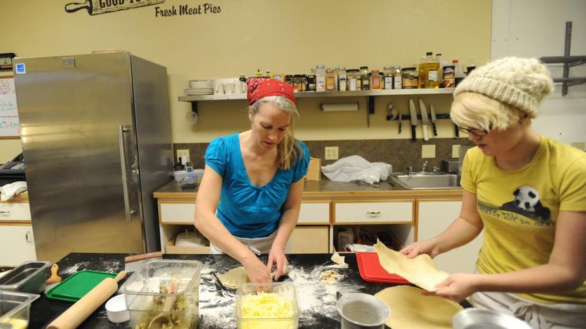 Holly Bevan-Bumford, owner of Good To Go, makes meat pies, while staff member Brianna Day stacks pastry in this file photo from 2012. Good To Go Meat Pies will be one of a variety of food vendors at the Ferndale Farmers Market this Friday.
