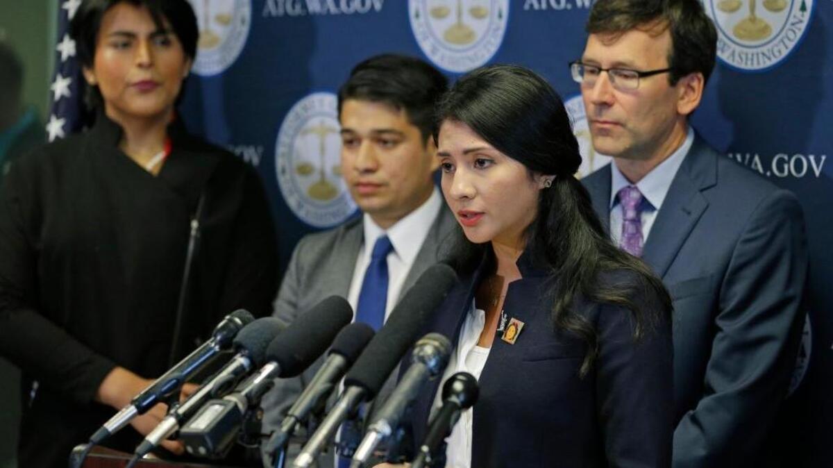 Faride Cuevas, second from right, a participant in the Deferred Action for Childhood Arrivals, or DACA, program, talks to reporters, Wednesday, Sept. 6, 2017, in Seattle, as Washington Attorney General Bob Ferguson, right, and two other DACA participants look on.