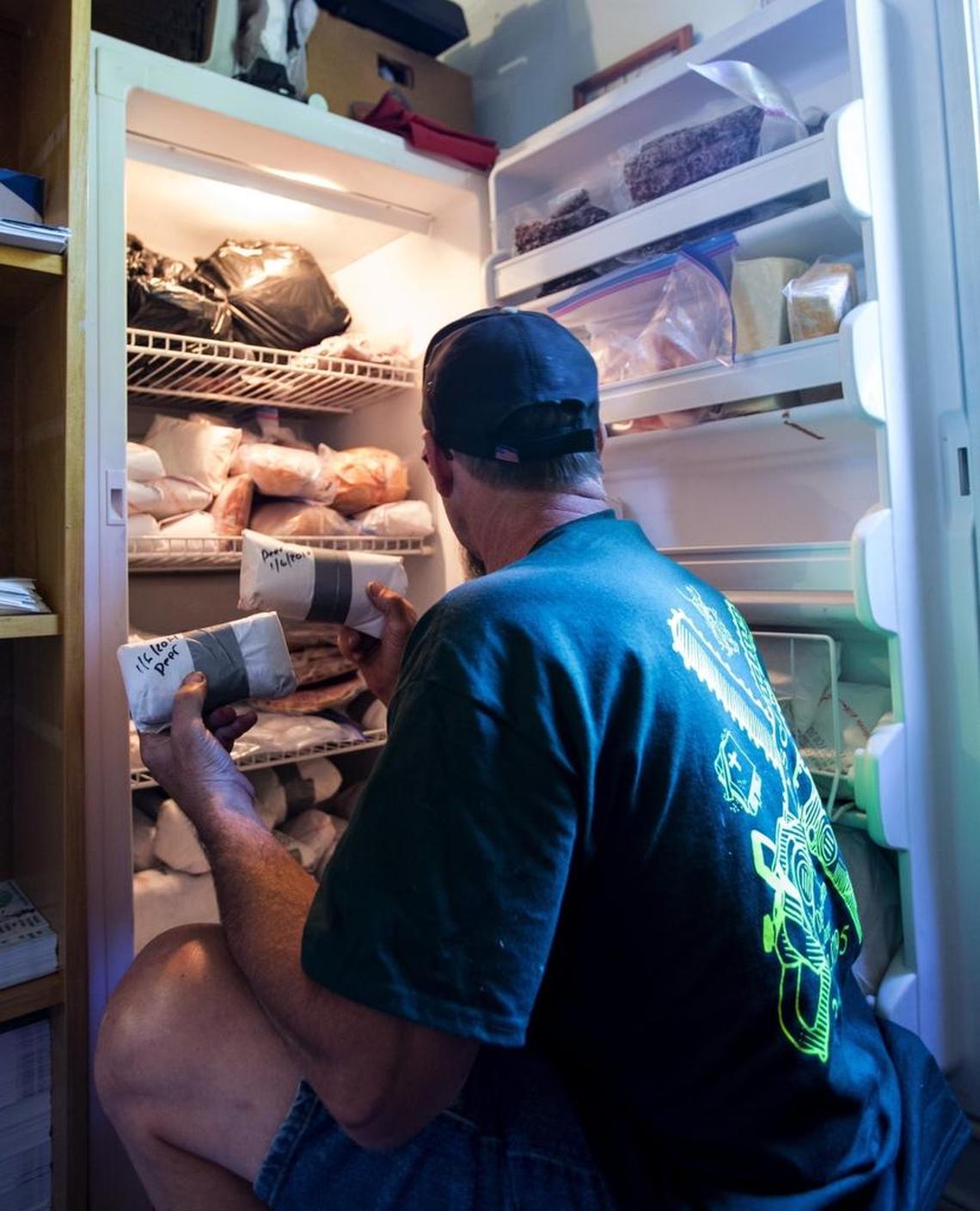 Tim Bento of Lynden looks through one of his freezers stocked with roadkill deer on July 18, 2017. 