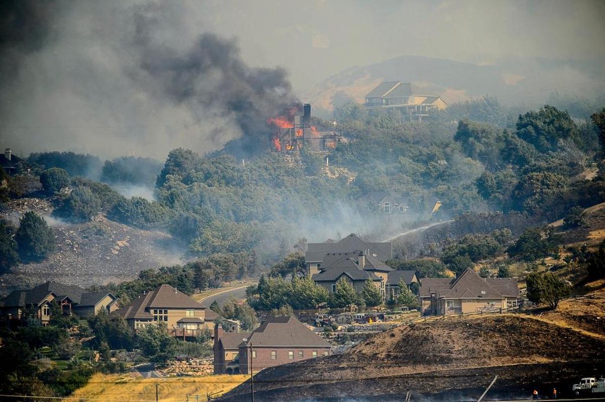 A home burns in at the mouth of Weber Canyon, Utah, Tuesday, Sept. 5, 2017. A fast-moving wildfire swept down a northern Utah canyon Tuesday morning, destroying homes, forcing evacuations and closing highways. A least five homes were burned as more than 1,000 people and two schools were evacuated amid high winds that fed the flames in a canyon north of Salt Lake City.