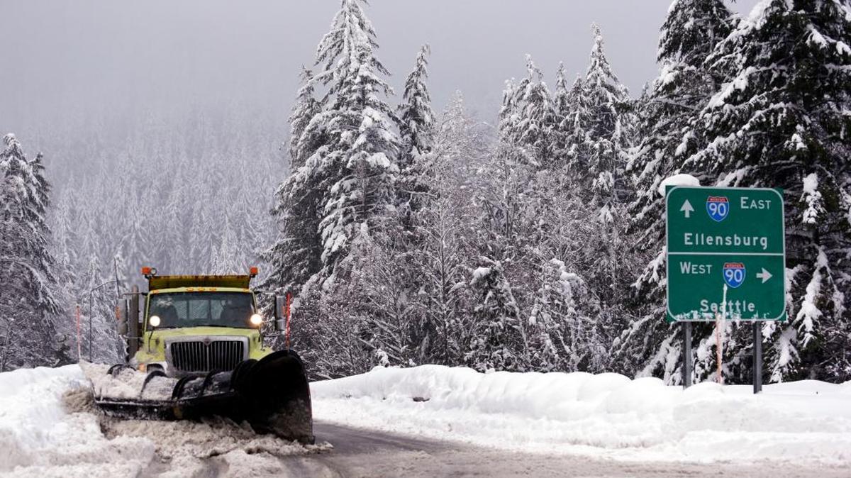 A snowplow clears an overpass of fresh snow over Interstate 90 at Snoqualmie Pass in January.