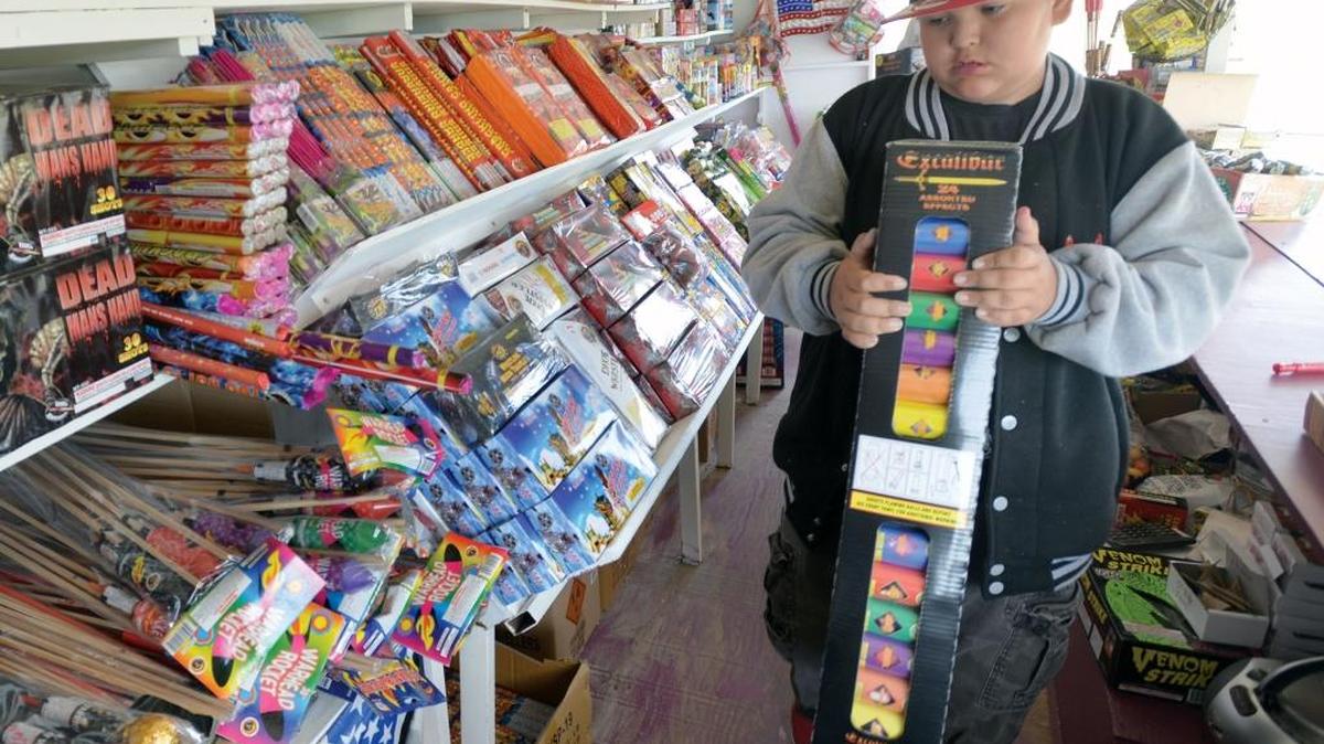 Carlos Castaneda Jr., 12, helps stock the fireworks stand owned by his family June 23, 2014, on Haxton Way on the Lummi Reservation. Blaine is considering limiting fireworks in parts of the city.