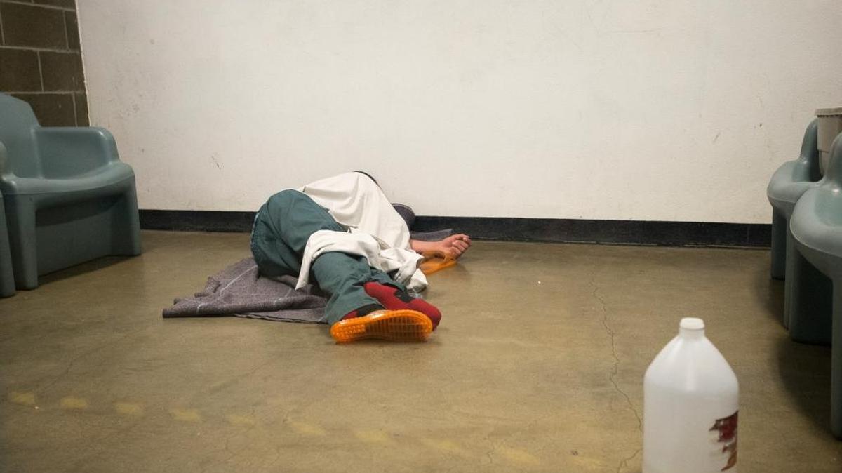 
An intoxicated inmate naps on the floor of a temporary holding cell shortly after being booked in but before being moved to more permanent housing on Thursday, July 30, at Whatcom County Jail in Bellingham, Wash. Cells designated for inmates with drug or behavior issues often fill quickly on nights and weekends, giving jail staff few options on where to house them.
