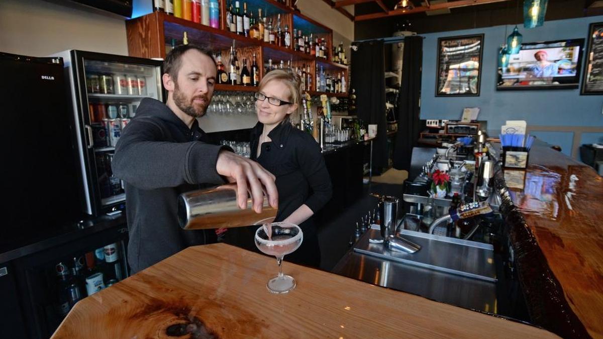 Kurt Hartmaier makes a drink, while his wife, Katy Hartmaier, watches at The Blue Abode Bar, their new bar in Barkley Village, Monday, Dec. 11. The bar is open seven days a week.