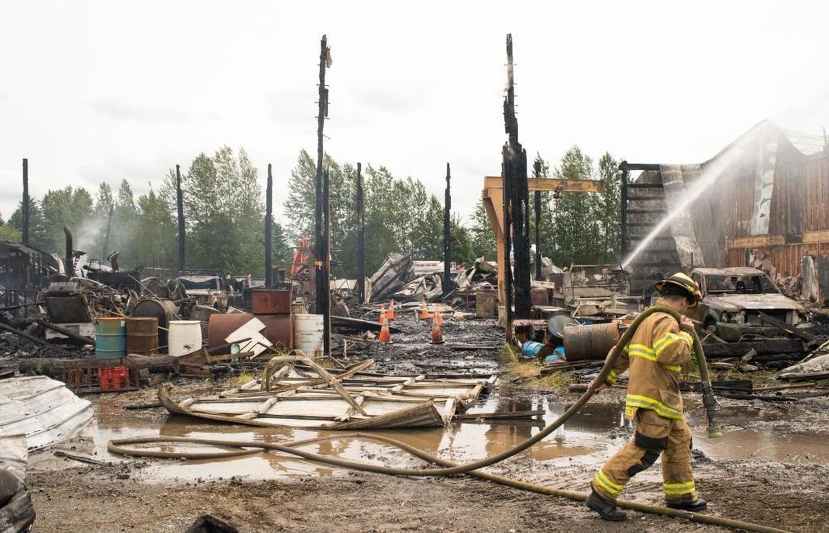 Firefighters from Whatcom County Fire District 7 work to put out remaining hot spots during a fire at Friberg Construction on Saturday, June 17, in Ferndale.