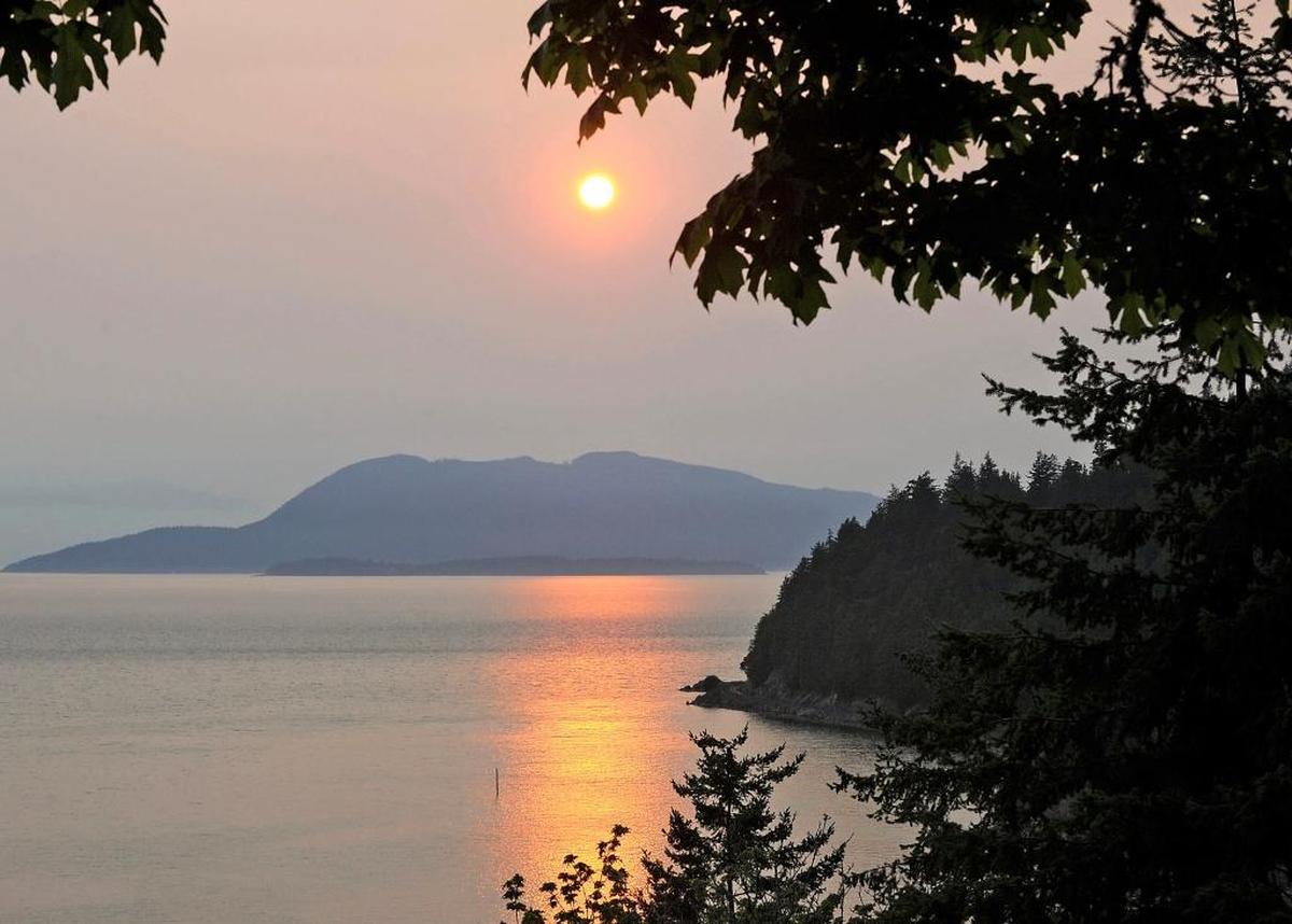 In this Tuesday, Aug. 1, 2017, photo, the sun is obscured by smoke from forest fires in Eastern Washington and British Columbia as seen from Chuckanut Drive in Skagit County near Blanchard.