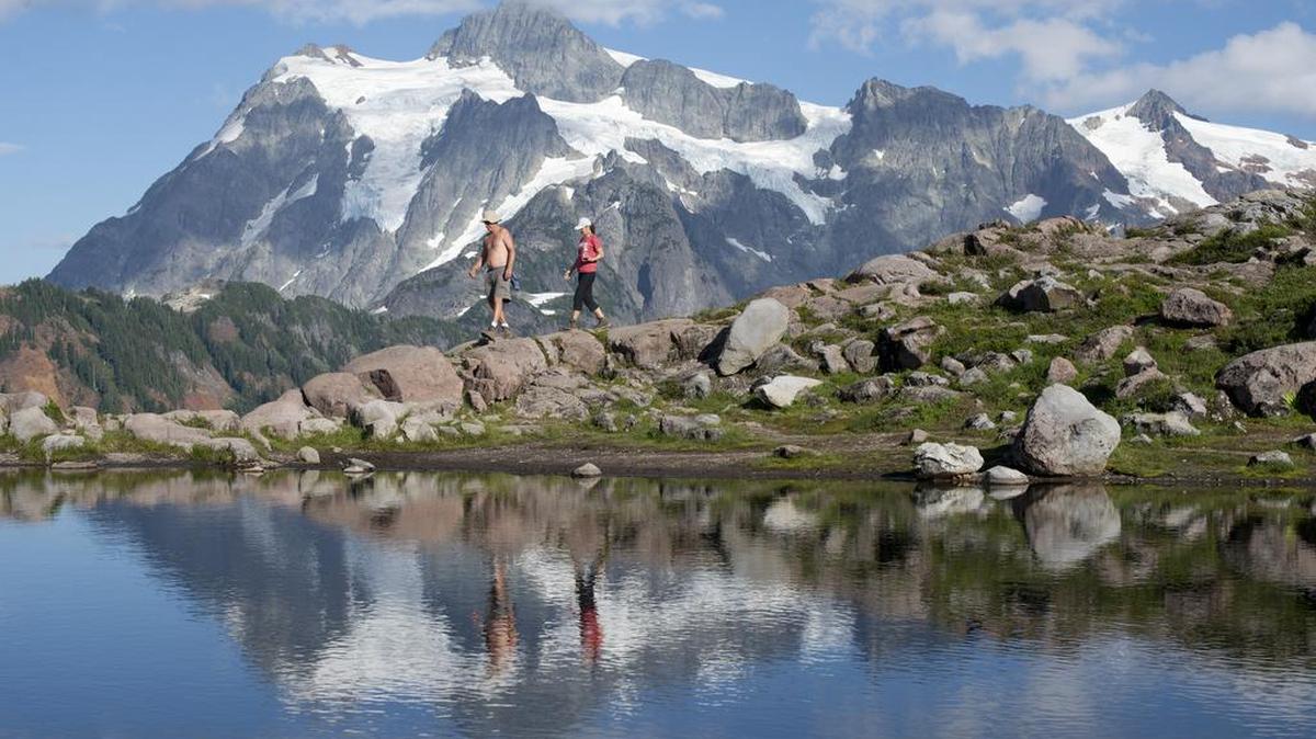 Rick Paul, left, and Sue Toy, right, walk along the Artist Ridge Trail, Aug. 26, 2014 at Artist Point. This week’s rain could complicate plans for a late-summer hike in the North Cascades, as forecasters say that snow will fall to elevations as low as 5,000 feet.
