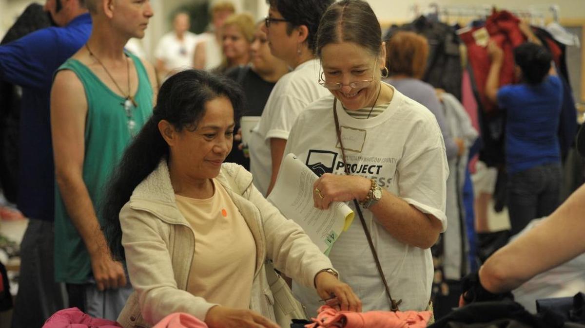 Nilda Owens, left, looks over clothing with volunteer Sandiford Dunstan-McGrail at the annual Project Homeless Connect at Bellingham High School on July 26, 2013. Volunteers are being sought to help out at the 2016 event.