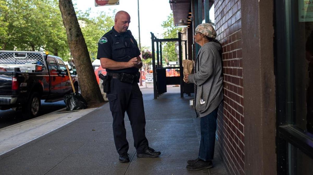 A Bellingham Police officer talks to a woman about drinking in public during a downtown foot patrol in this file photo.