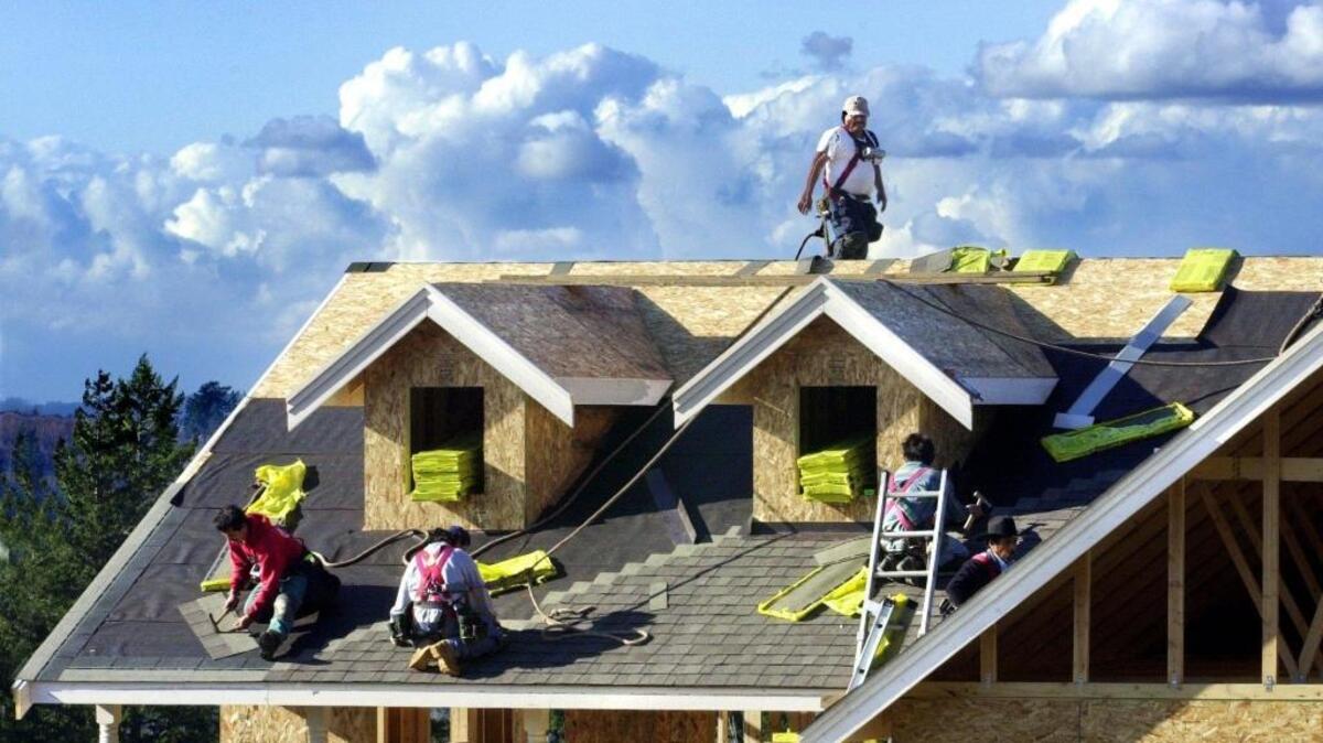 Roofers put shingles on a house in Bellingham. At the end of June Whatcom County had an estimated 1,300 more construction jobs than a year ago.