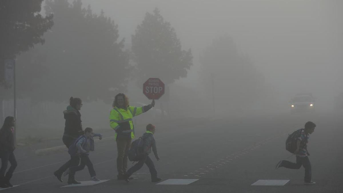 Blaine Public Schools paraprofessional Tricia Johnson stops traffic on H street in Blaine for a group of students headed to school in the fog on Oct. 24, 2013. Visibility could be as low as a quarter-mile in some areas during the morning commute times this week, according to National Weather Service. Drivers should allow greater distance for cars and pedestrians.