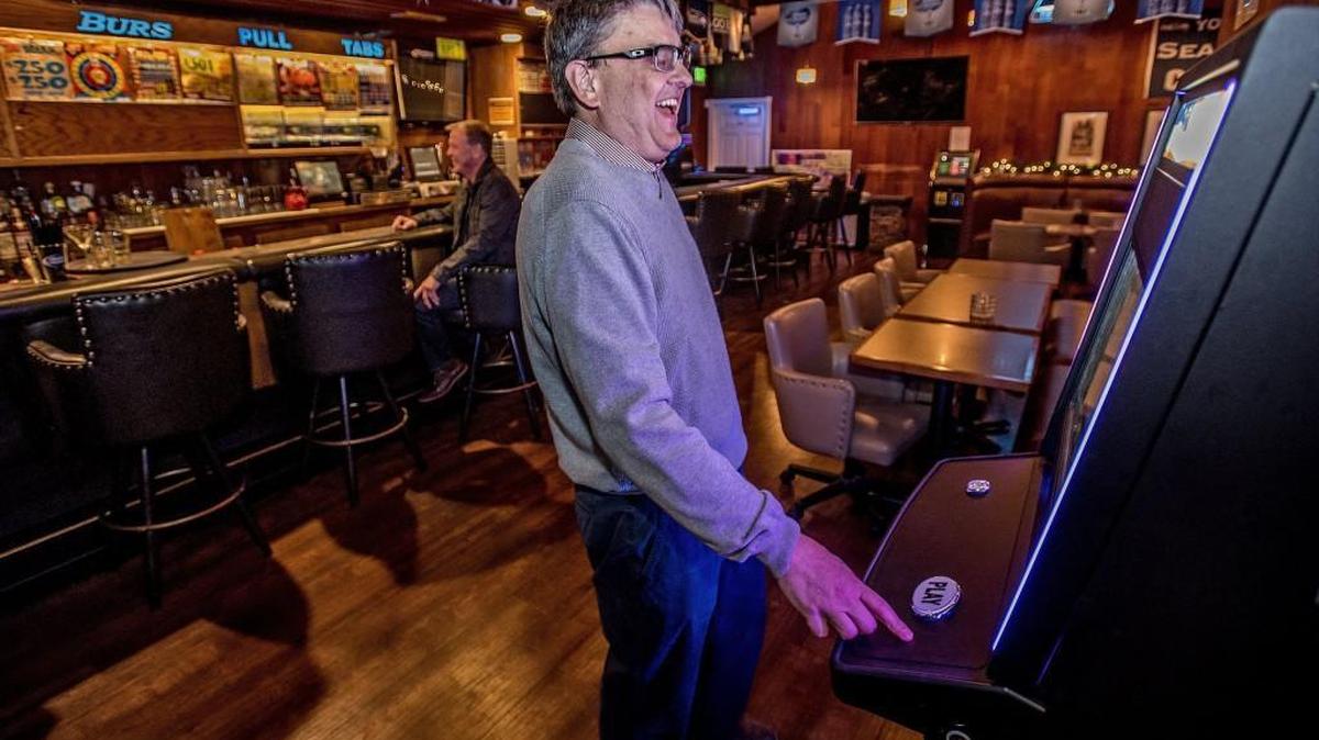 Pat Tompkins, of Sound Amusements, demonstrates Thursday how an amusement game machine works inside the bar of Burs Restaurant in Lakewood.