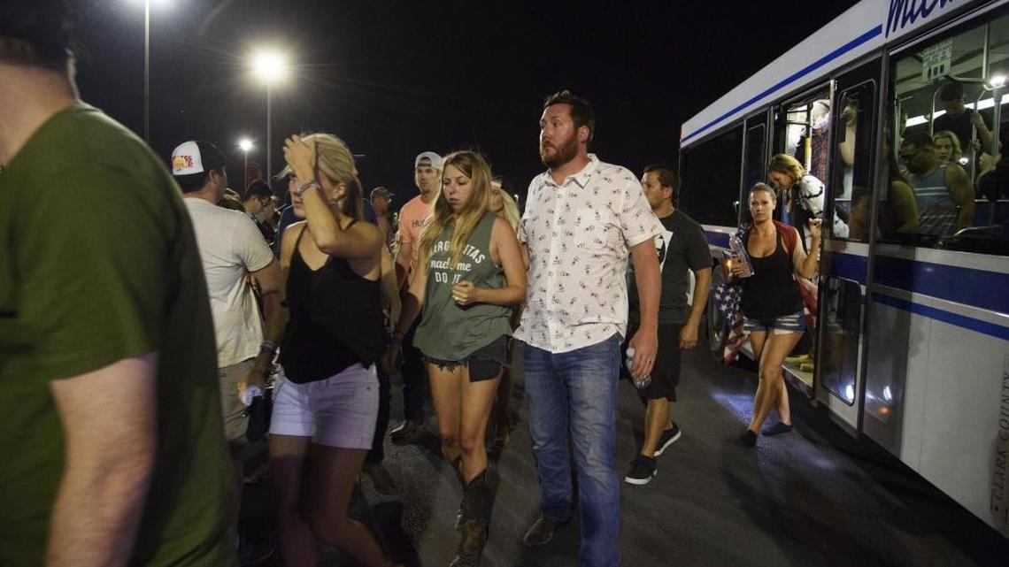 People arrive to Thomas & Mack Center via bus after hiding inside the Sands Corporation plane hangar after a mass shooting in which dozens were killed at the Route 91 Harvest country festival on early Monday, Oct. 2, 2017, in Las Vegas.