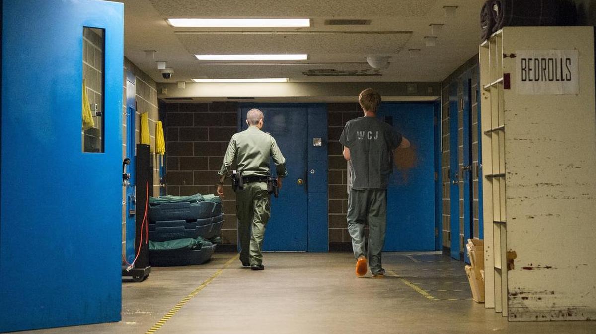 A deputy escorts an inmate to a minimum security housing area on Saturday, July 4, 2015 at Whatcom County Jail in Bellingham, Wash.