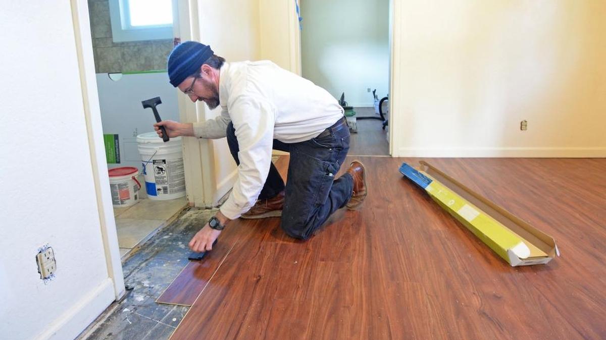 Lydia Place facilities manager Chris Ludjin installs a new floor Feb. 23, 2016, in one of the homes Domestic Violence & Sexual Assault Services of Whatcom County and Lydia Place bought in Bellingham to house homeless and abused women.