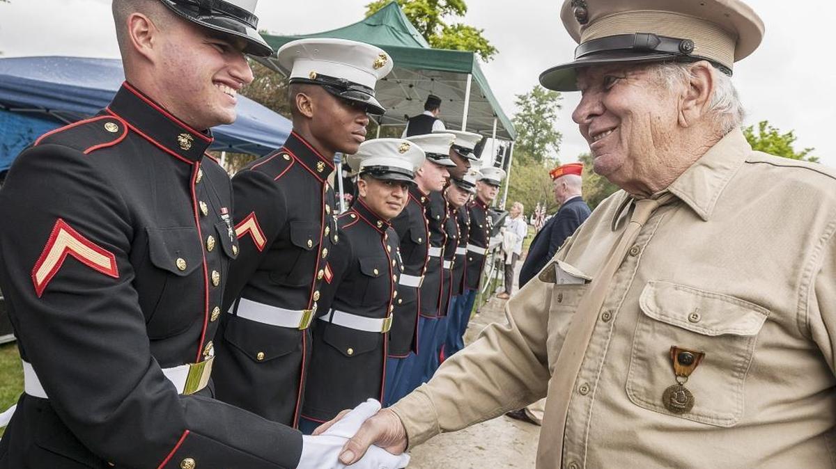 World War II veteran Bob Lemke of Bellingham, Wash., right, shakes hands with Pfc. Matthew Montanez during the 50th annual Festival of Flags and Remembrance Ceremony at Greenacres Memorial Park in Ferndale, Wash., on Monday, May 25, 2015.