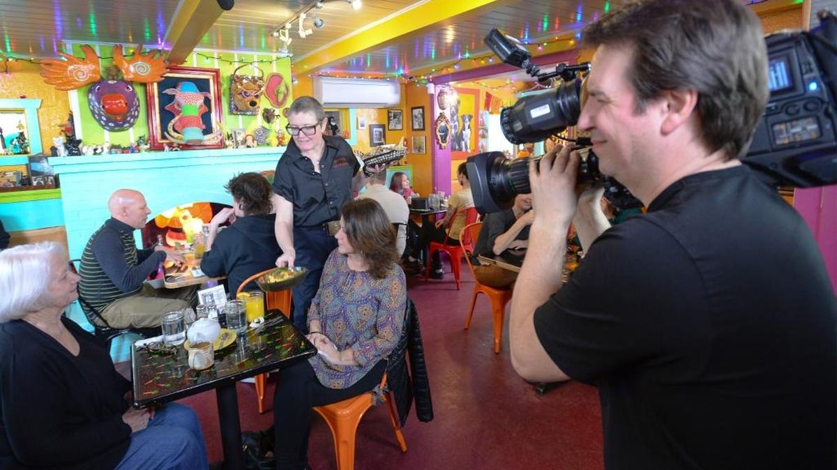 Homeskillet co-owner Tina White serves lunch to her mother-in-law Nancy White, left, and sister-in-law Nancy Edwards while cameraman Steve Lindsay films them for an episode of the Food Network Canada show ”You Gotta Eat Here!” at the restaurant in Bellingham on Friday, Feb. 19, 2016.
