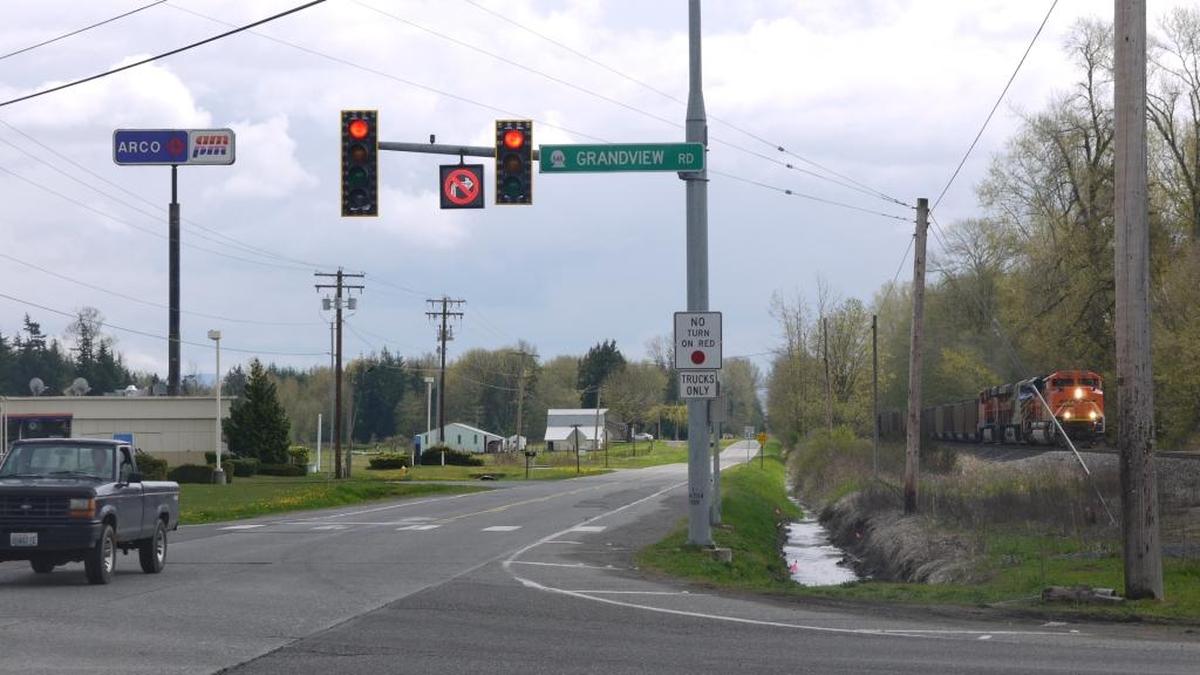 When two signs are posted together, the second one modifies the first. At Grandview Road and Portal Way, the “No Turn on Red” sign applies only to “Trucks Only.” Supplemental plaques can also specify a time of day when the regulatory sign is in effect.