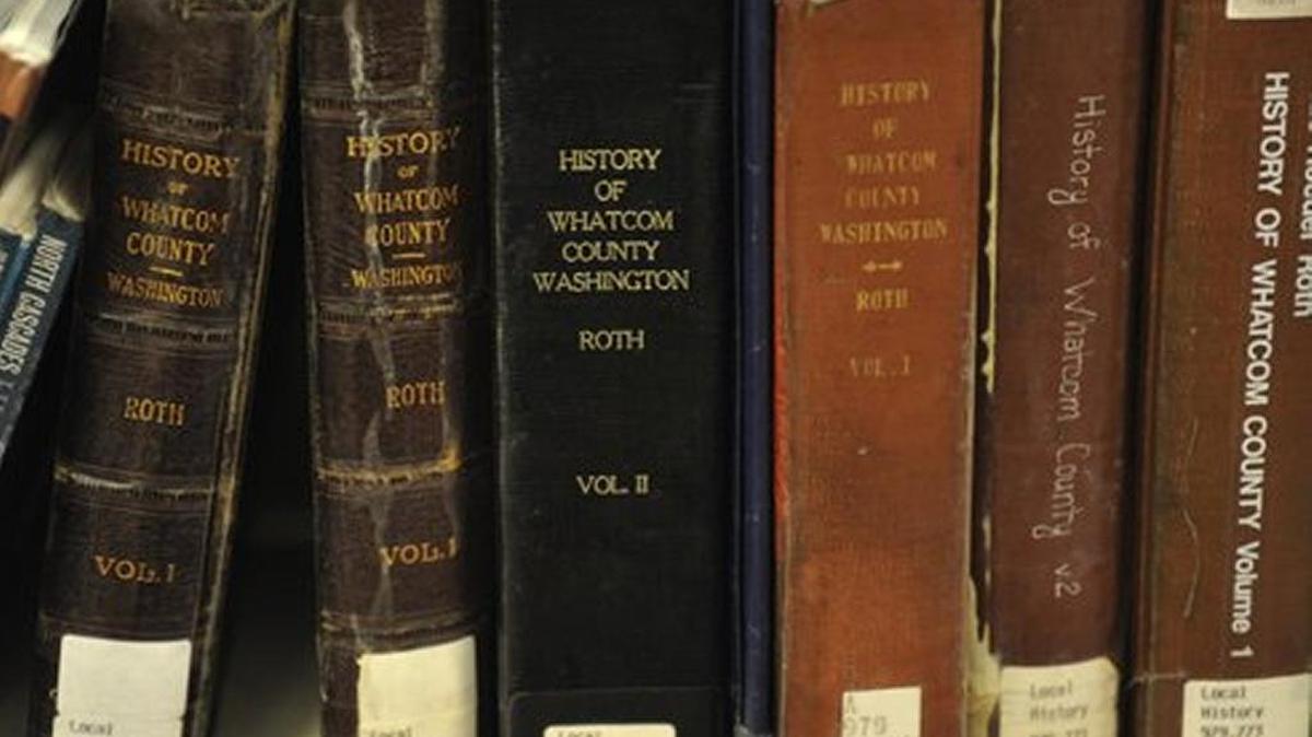 Whatcom County history books are shown at the Bellingham Public Library. A behind-the-scenes tour of the library is being moved to Mondays in April and May.