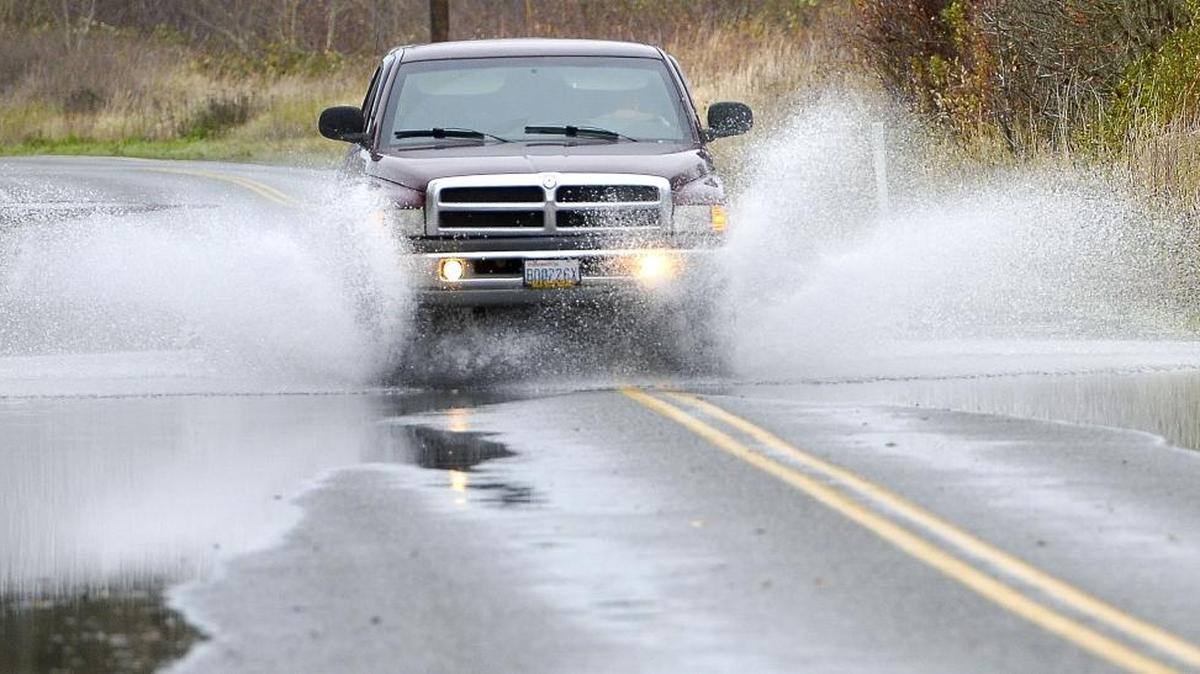 A pickup truck drives through receding flood water on Marine Drive west of Ferndale Road on Monday, Nov. 16, 2015. Another storm this week flooded the road. The section between Rural Avenue and Lummi Shore Drive remained closed as of Thursday morning.