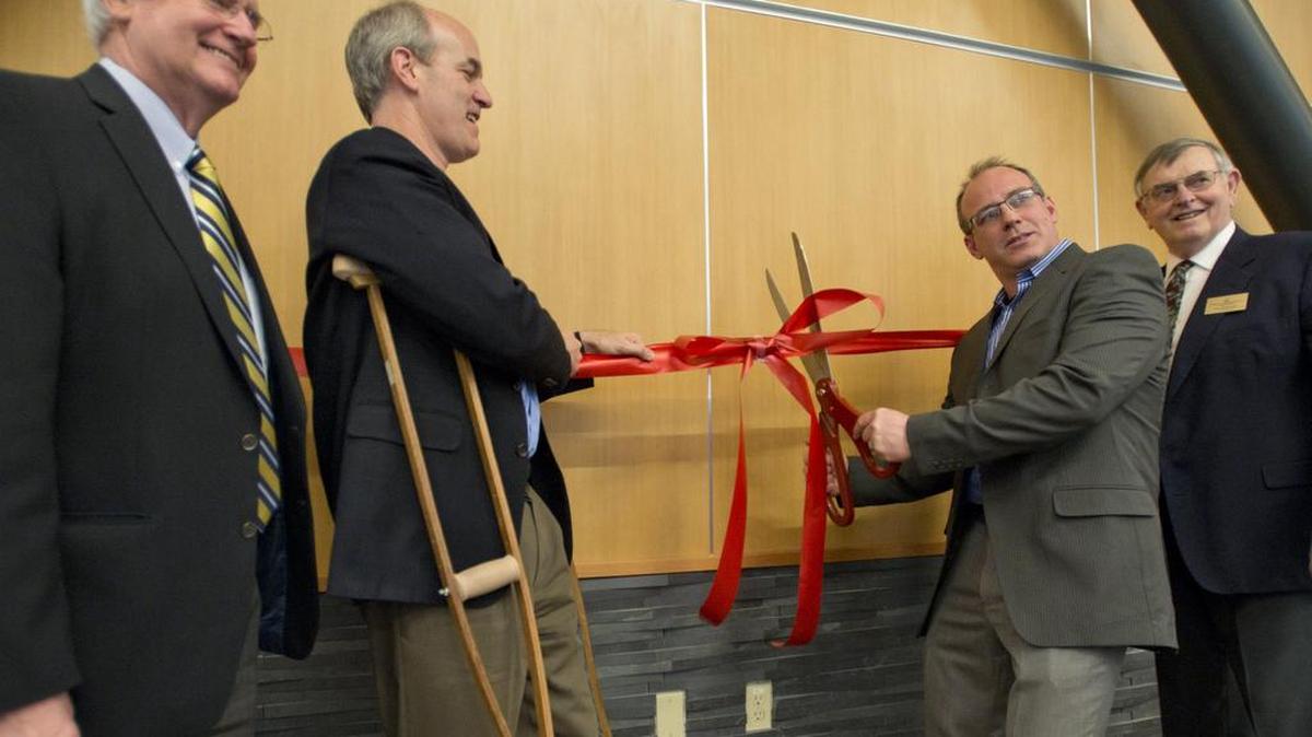 Port of Bellingham Commissioner Mike McAuley cuts a ceremonial ribbon Feb. 20, 2014, to celebrate the expansion of Bellingham International Airport. McAuley, after years of trying, on Tuesday, Jan. 5, 2015, got the commission to shift some meeting times to evenings to allow the working public to more easily attend.