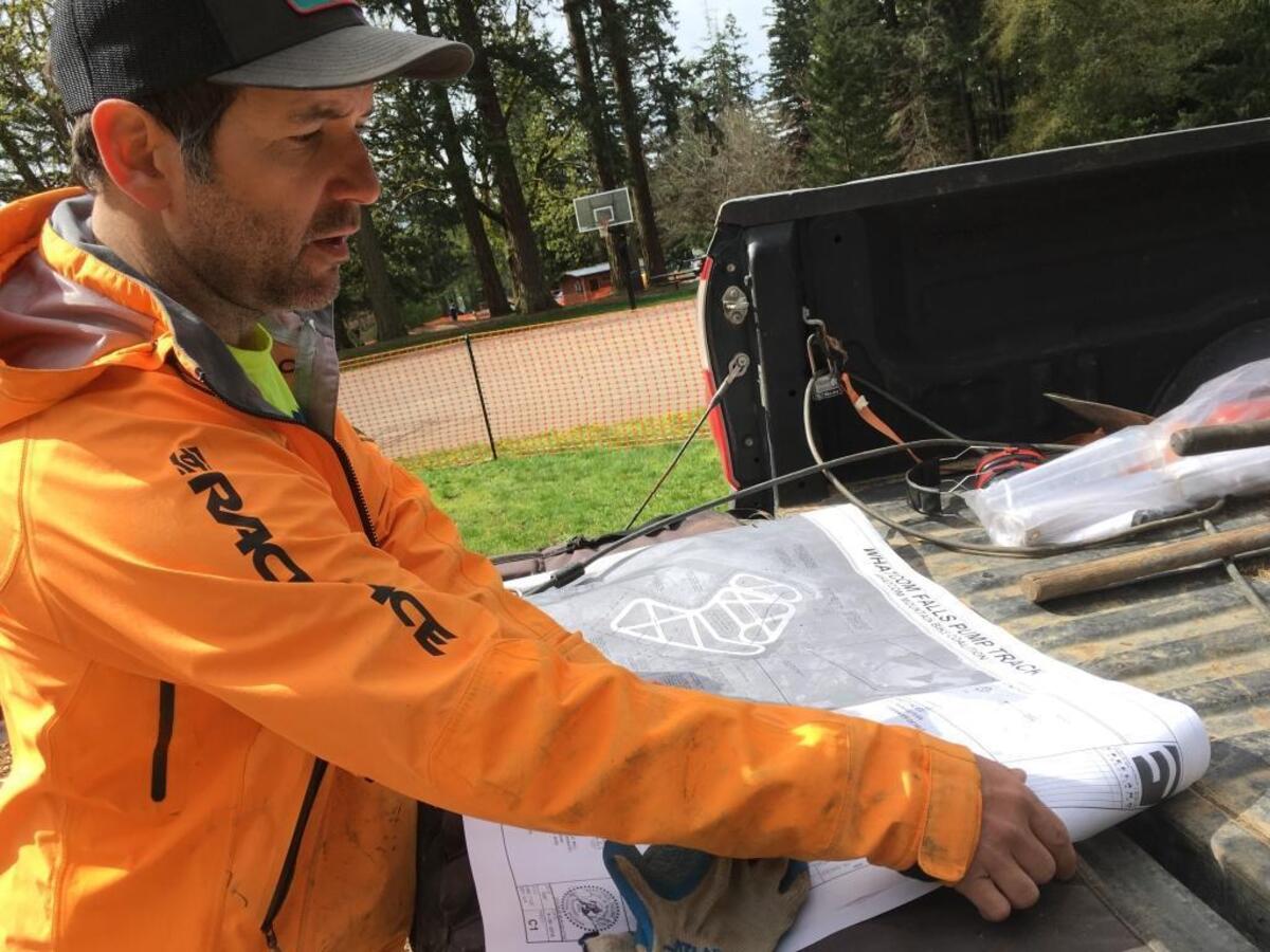 Eric Brown of the Whatcom Mountain Bike Coalition examines plans for the “pump track” project as ground broke this week at Whatcom Falls Park.