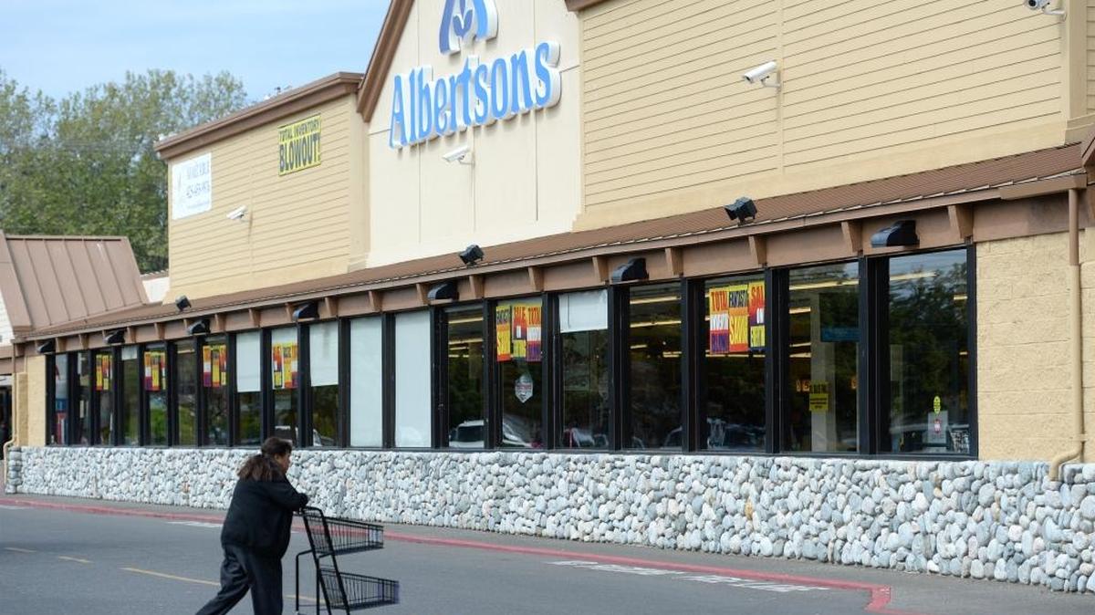 Signs proclaiming big discounts and an inventory blowout line the windows of the Birchwood neighborhood Albertsons grocery store Thursday, April 28, 2016. The store is closing May 7, leaving residents without a nearby grocery.