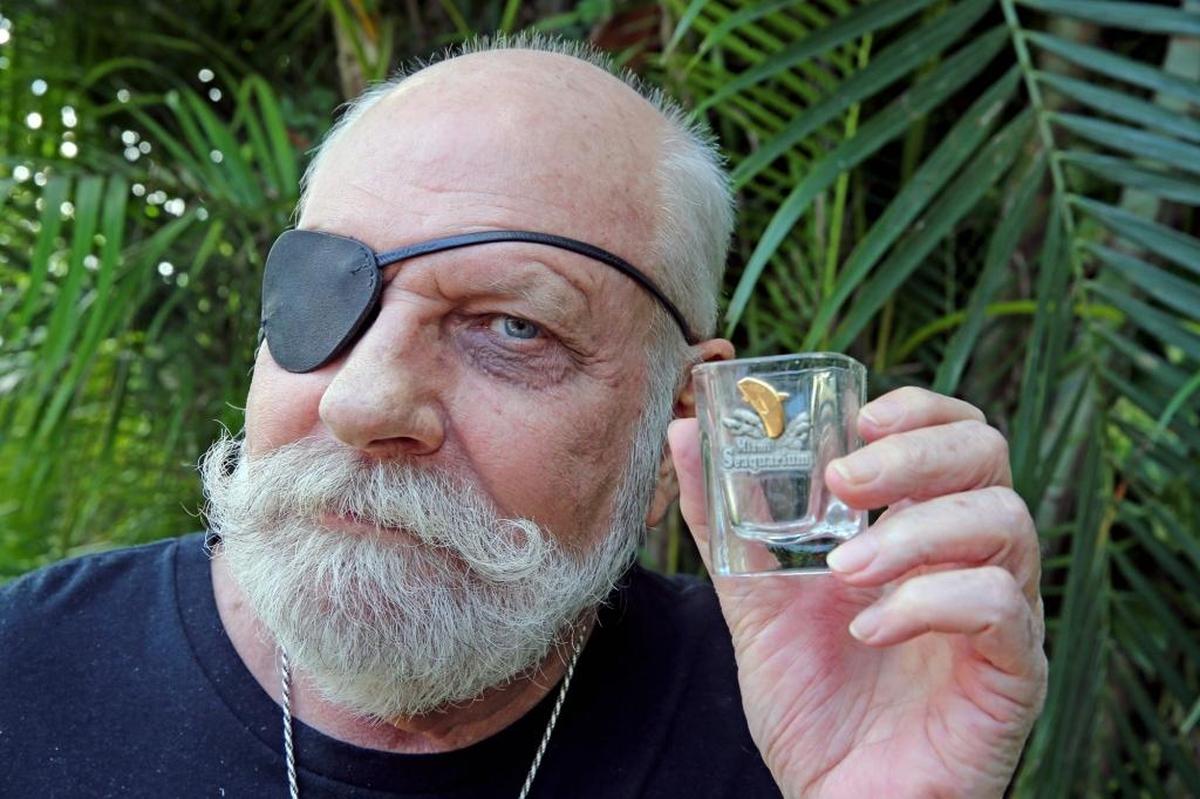 Russ Rector holds a Miami Seaquarium shot glass at his Fort Lauderdale home, November 2, 2017. Rector believes moving Lolita, an orca, that has lived most of her 50 years alone in an arguably small tank at the Miami Seaquarium, would face a number of hurdles to be successfully transferred to a netted, seaside sanctuary near her originial home by Puget Sound.