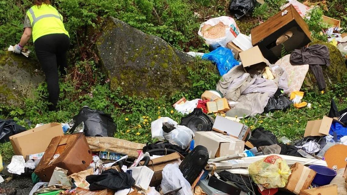 A Whatcom County worker helps remove trash that was dumped Wednesday, May 3 at Stimpson Family Nature Reserve.