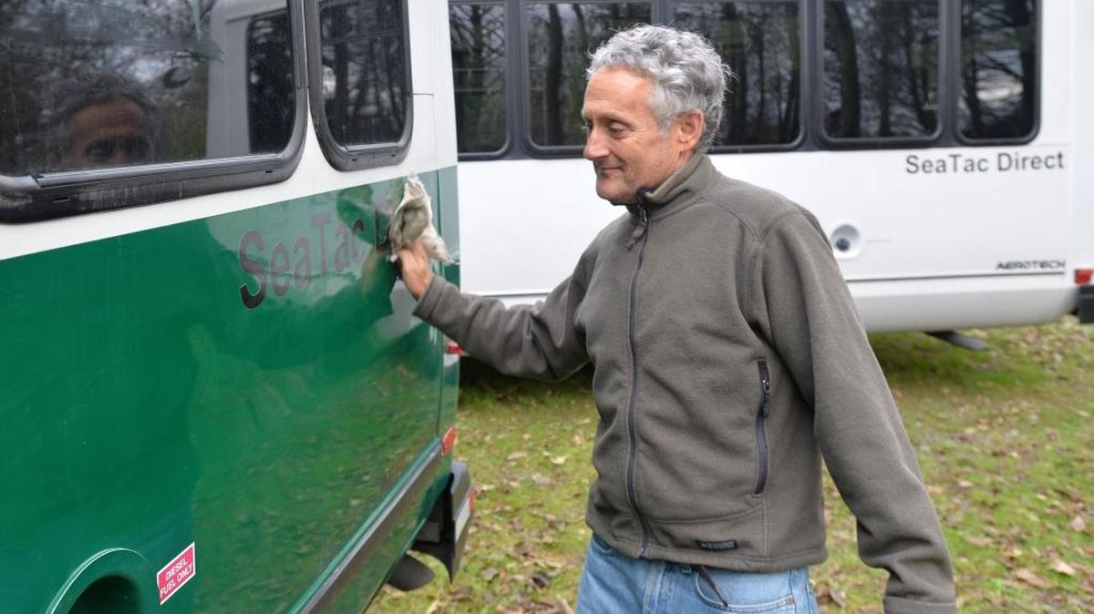 SeaTac Direct owner Joel Kronenberg cleans one of his shuttle vans at his garage north of Bellingham Oct. 24, 2014. The business, which offers direct service from Bellingham to SeaTac airport, is launching a weekly craft brewery tour around the Bellingham area.