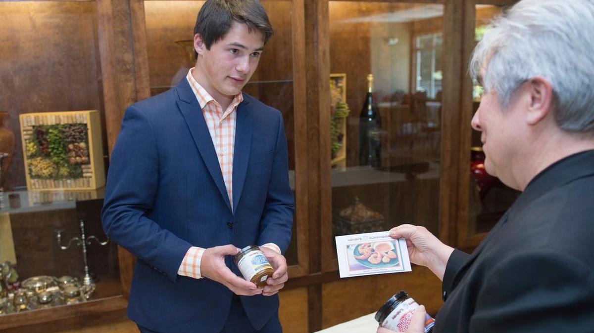 Henry Miller, 18, of Henry’s Humdingers talks to Diane Kamionka of the Northwest Innovation Resource Center after a presentation at the Bellingham Golf and Country Club on Wednesday, June 17, 2015. Miller will be pitching his products on QVC on Monday, June 22.