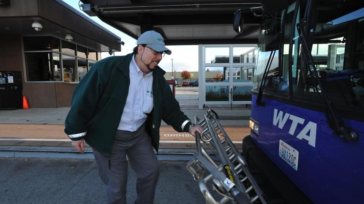 In this Nov. 10, 2011, photo, Whatcom Transportation Authority’s Steve Sage puts up a bike rack on his bus at the Cordata bus station in Bellingham. Sage, WTA’s most senior operator, has logged more than 1 million miles without a crash that was his fault.